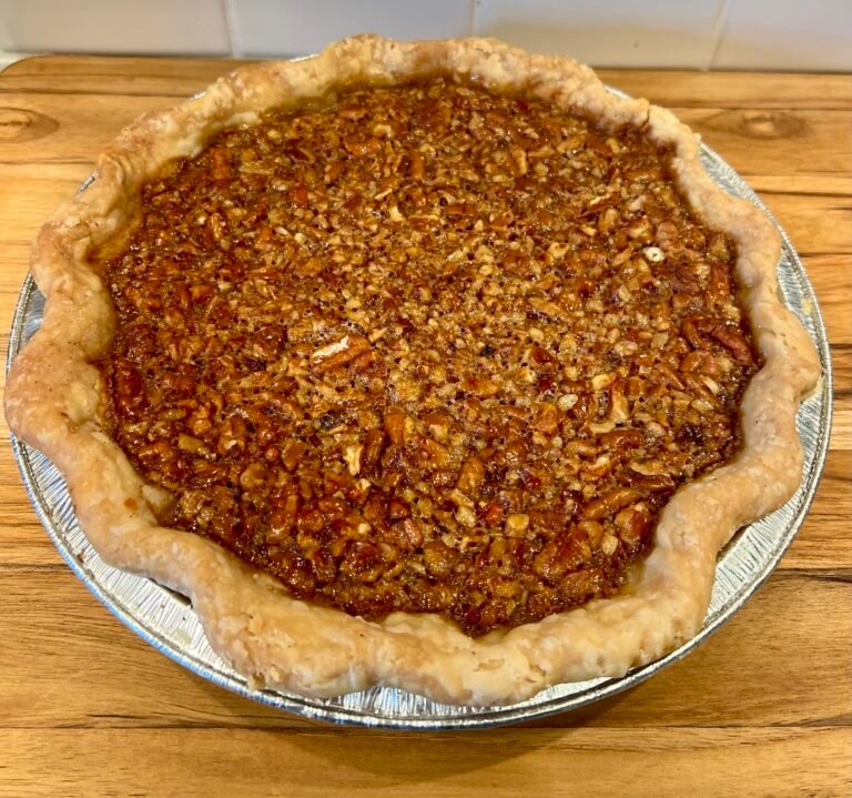 Homemade classic pecan pie with a golden, flaky crust and toasted pecan filling in a glass pie dish.